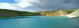 A turqouise-blue lake with steep sides