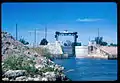 View ESE of Dike Canal Point locks and SCFE train bridge over the West Palm Beach Canal during US Army Corps of Engineers rehabilitation. Lake Okeechobee is behind the photographer. Canal Point, Florida, 1968.