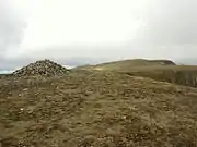 Summit cairn on High Crag, with Helvellyn seen beyond