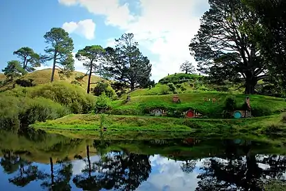 Hills with inset, round doors. Reflected in water.