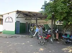 People gathered outside of a green and white building.