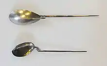 Two long-handled spoons, the "handle" being a tapering metal spike