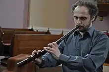 man playing the cornetto in a church