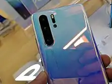 Image 8The back of a Huawei P30. It features three rear-facing camera lenses with Leica optics. (from Smartphone)