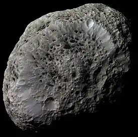 Image 8HyperionPhoto credit: Cassini orbiterHyperion, a moon of Saturn, is one of the largest highly irregular (non-spherical) bodies in the Solar System. Enhanced image processing was used to bring out details and color differences in this photo taken by the Cassini orbiter. Hyperion is entirely saturated with deep, sharp-edged craters that give it the appearance of a giant sponge. Dark material fills the bottom of each crater.More selected pictures