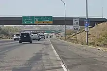 Looking from the shoulder of a freeway at an overpass with signs reading "To Interstate 82 - Yakima, Pendleton" and "West SR 240 - Wellsian Way, Vantage" with route markers for Interstate 182 and U.S. Route 12 off to the side.