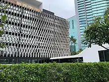 The IBM Building with a smooth white corridor leading to a white cube-shaped structure sticking out of its side.