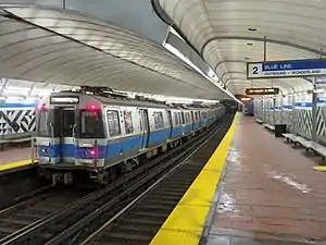 A subway train in an underground station with an arched roof