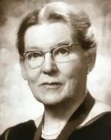 Black and white portrait photograph of Isabella Forshall. She is wearing glasses.