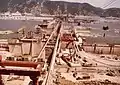 Overview of the construction site from Davidovac on the Yugoslavian side towards Gura Văii on the Romanian site, the viaducts of the new DN6 trunk road and of the Craiova-Caransebeș railway are also seen under construction on the Romanian side