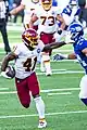 J. D. McKissic applies a fend to the face mask of an opponent during an American Football game