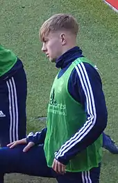 Young man in sports kit stretching