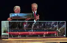 Former President Carter holding a model of the boat that carries his name.