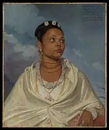 An oil painting depicting Joanna de Silva, an Indian woman, from waist up, looking into the distance. She wears delicate white clothing and has jewellery around her neck and in her hair, and a ring on her finger.  An inscription states Joanna de Silva, a native / of Bengal, the faithful / and affectionate Nurse / of the Children of / Lieutenant Colonel Charles Deare / Painted by Will:m Wood 1792