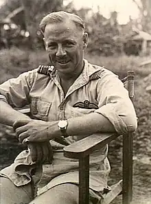 Half-length portrait of seated man in tropical military uniform with pilot's wings on left breast pocket