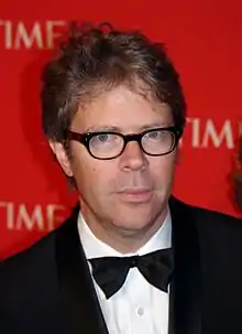 A spectacled Jonathan Franzen  is pictured in a tuxedo on a Time magazine red carpet. His short hair is somewhat untidy.