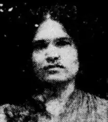 A young South Asian woman, with dark hair parted center, wearing a sari.