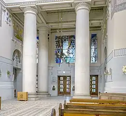 The church lobby, with chandelier, mosaics and stained glass window.