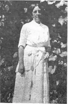 photograph is Katherine Sleeper Walden circa 1910. She is wearing a white dress and has a key hung about her waist