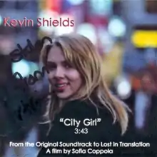 An image of blonde-haired woman smiling from a distance. The city street behind her is out-of-focus.