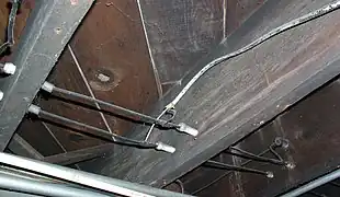 Wiring running through tubes, and turning a corner supported by a knob.  Notice the direct splice with more modern (1950s-era) non-metallic–sheathed cable.  This type of connection is forbidden by the National Electrical Code, and a junction box should have been used.