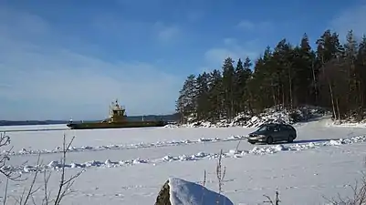 Koivukanta ferry in winter and parallel ice road for lighter vehicles