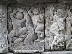 Balarama is prying apart the jaws of Kaliya.