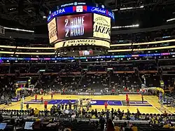 A colorful basketball court with a large-screen television display hanging above it