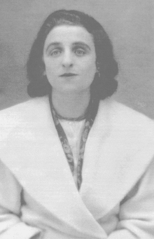 Woman with shoulder length brown hair wearing a white coat