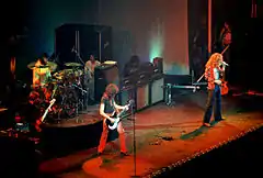 A color photograph of the band Led Zeppelin on stage