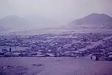 View of shacks in settlement with mountain behind