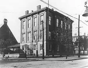 Three-story, square brick building on a corner lot