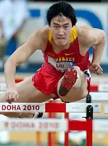 Liu Xiang jumping through hurdle during his 110 meters hurdles race