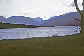 Looking up the loch from near its outflow. The furthest mountain is Slioch, the one on the right overtopping the nearer shoulder is the Fisherfield Munro Mullach Coire Mhic Fhearchair