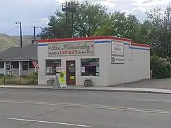 Exterior of a white building on a mjulti-lane road