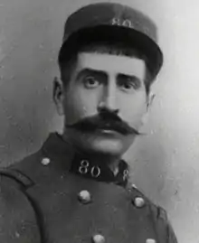 A black and white portrait photo of a man in French Army fatigues wearing a cap