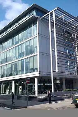 The corner of a square glass-fronted building