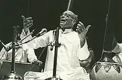 Black and white photograph of an old man singing.