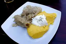 Mămăligă with a spoonful of sour cream and sarmale