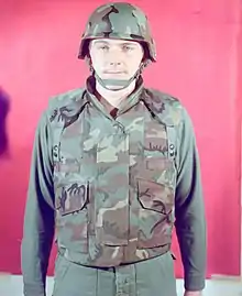 A man in 1975 modelling an early ERDL-patterned prototype of the PASGT vest, with two PALS webbing strips on the front.