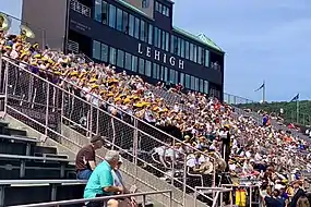 Marching 97 performing at the stadium in 2019 with the John J. Harmon '59 Sky Box in the background