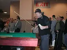 McCready holding a cue in front of a pool table