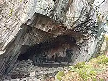 Photograph of entrance to "bedroom" area of cave, which is above and to the right of the main entrance to the "living room" area. The inscription can be seen low down on the left hand wall at the entrance.