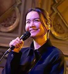 Mitksi smiling while holding a microphone.