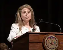 Kramer speaking at a podium with the seal of Montgomery County on it during a meeting of Governor Larry Hogan's cabinet members