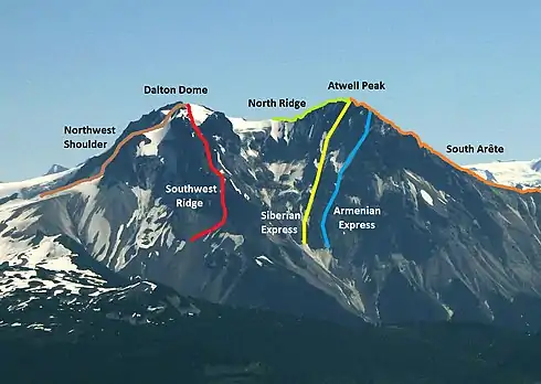 A dark, lightly snowed mountain with two summits and coloured lines depicting paths by which the mountain can be climbed.