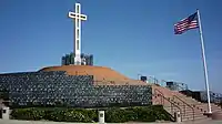 White cross on top of a hill and American flag