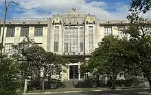 Front of three-story building against a blue sky