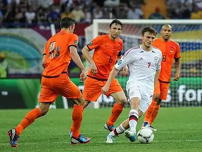 UEFA Euro 2012 match between Netherlands and Denmark. Two teams in different colored uniform.