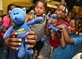 Children at the Boys and Girls Club of Chicago show off their Navy "Blue Bears" given to them during a visit by Vice Adm. David J. Venlet.